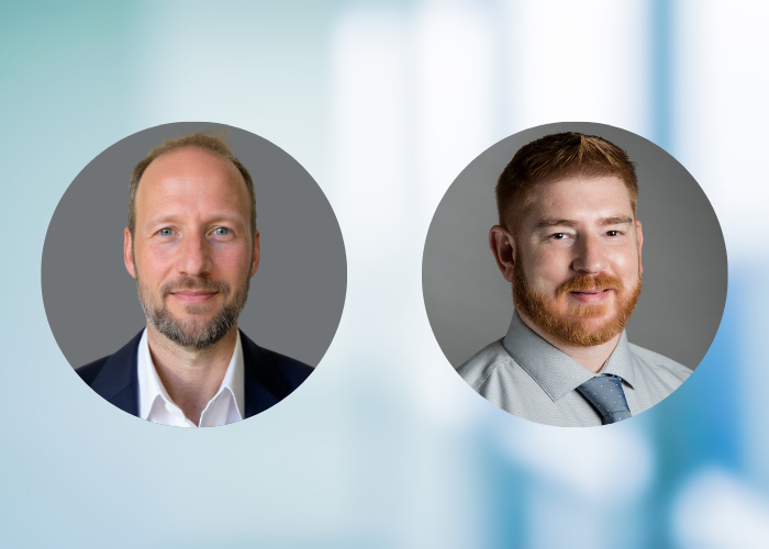 Two professional headshots of men in circles on a blurred blue background. The man on the left, Dr. Platts-Mills has a beard and wears a suit; the man on the right, Jason Bryant has a beard and a tie.