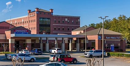 Parking lot in front of a red-brick building labeled 