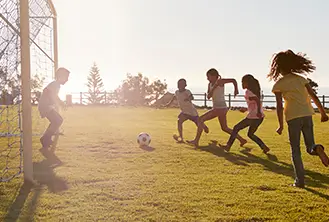 group of children playing soccer in the park