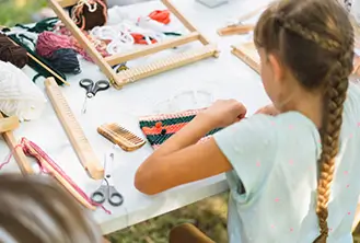 Girl sitting and doing crafts at a table