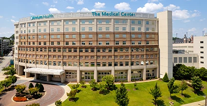 Aerial exterior view of The Medical Center, Atrium Health Navicent, a large curved multi-story building with a manicured green lawn.
