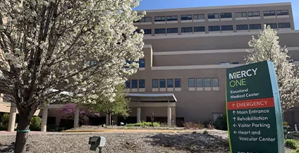 sign that says mercy one next to gray building