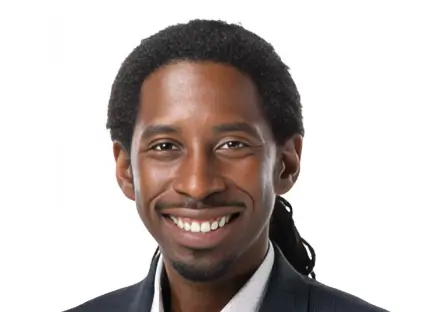 Headshot of Richard T. Benson, smiling, wearing a grey patterned blazer and a white button-down shirt.