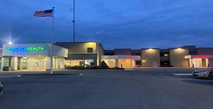 Exterior view of Mercy Health Allen Hospital, featuring a modern brick and glass building with a circular driveway and manicured landscaping.